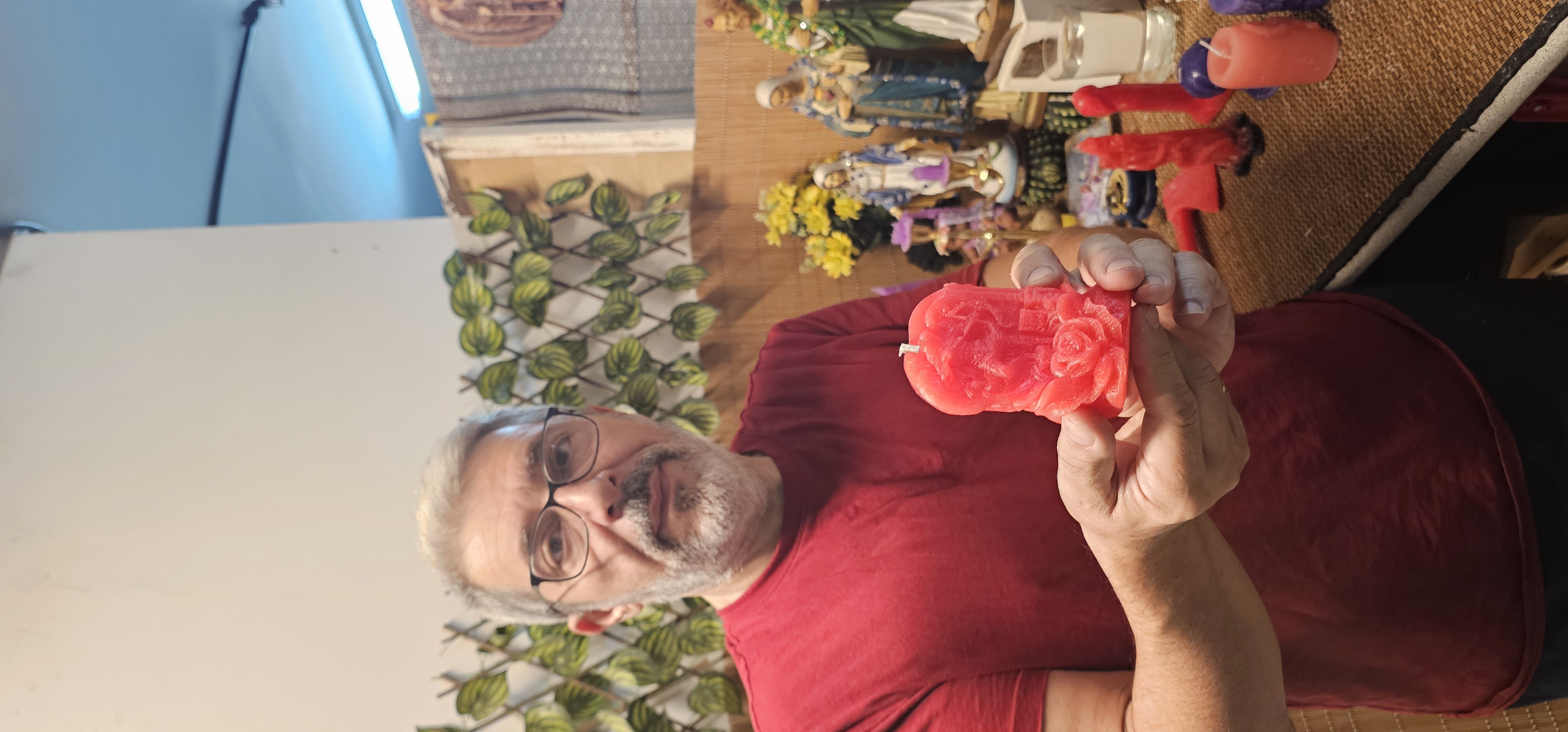 Adel Soso sosteniendo una vela roja preparada para un encendido personalizado